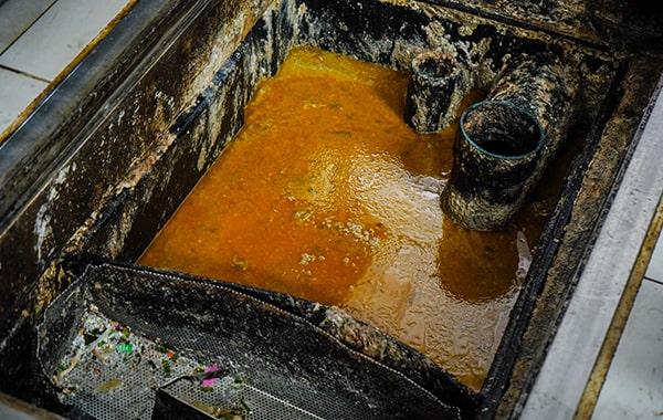 foul odors, slow draining sinks, and visible grease build-up are signs that your grease trap needs cleaning